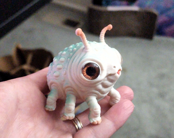 An actual hand-painted Grublet resting in the artist’s hand